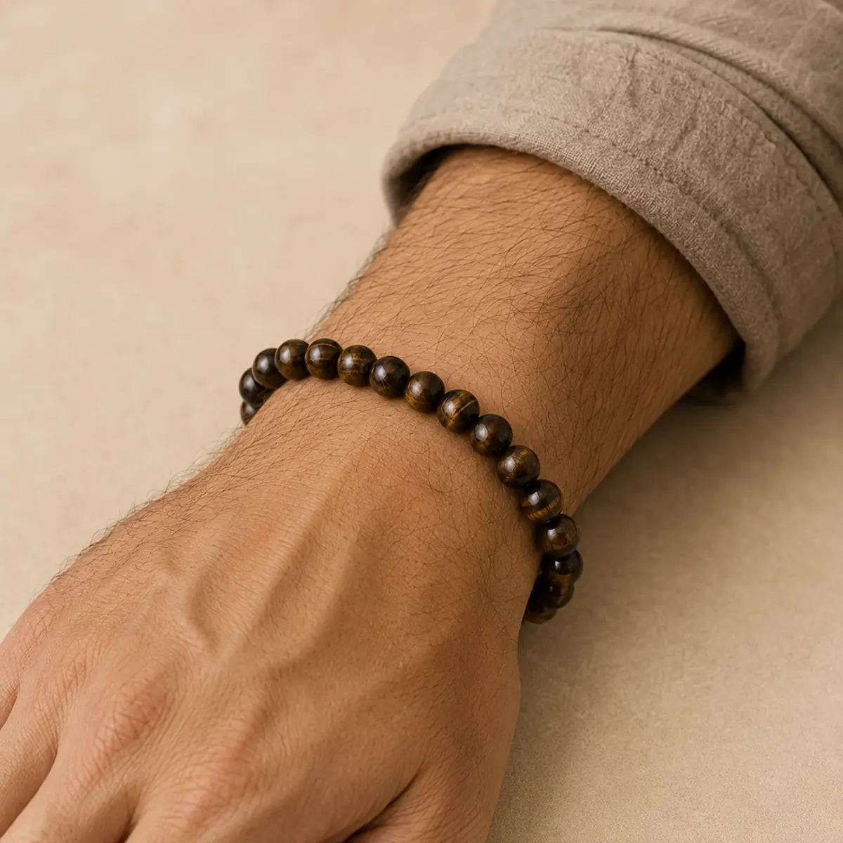 Bracelet en œil de tigre naturel porté sur un poignet d’homme