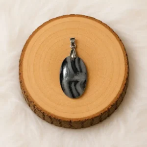 Pendentif Jaspe Zèbre en pierre naturelle posé sur un rondin en bois