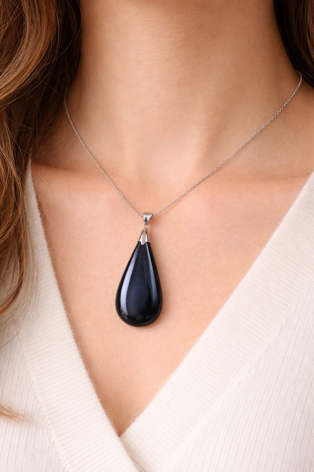 Pendentif hématite en pierre naturelle porté autour du cou sur chaîne argentée