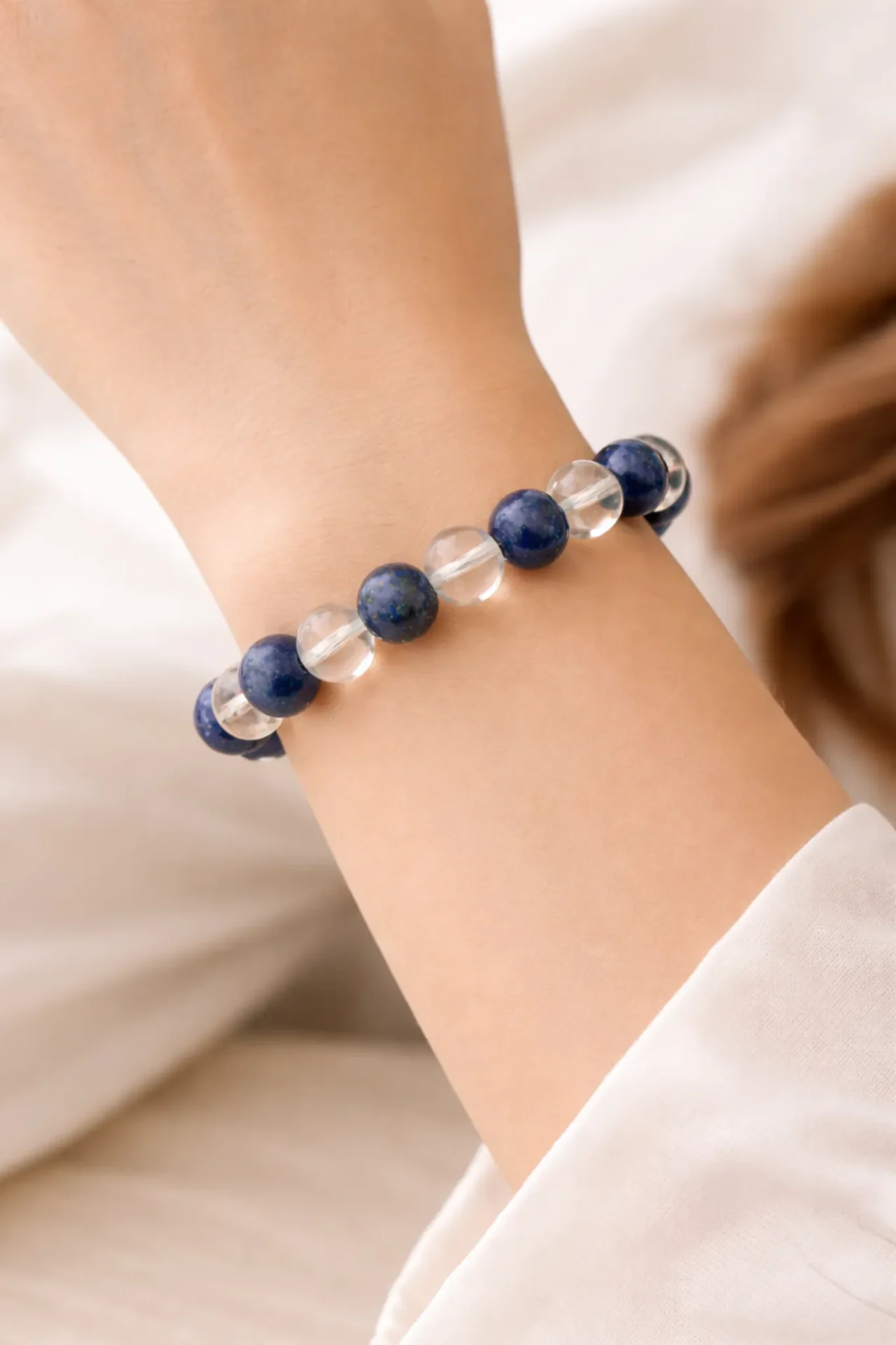 Bracelet anti migraine en lapis lazuli et cristal de roche porté au poignet