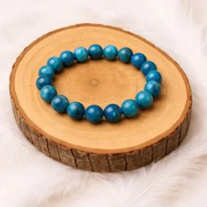 Bracelet apatite en pierre naturelle posé sur rondin en bois