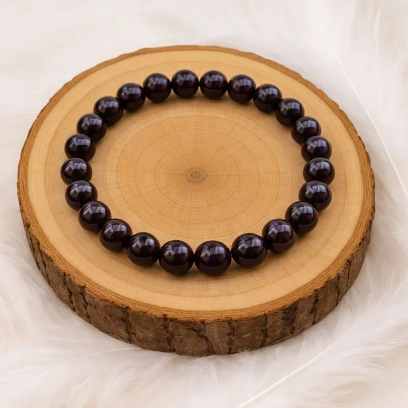 Bracelet en grenat naturel présenté sur support en bois.