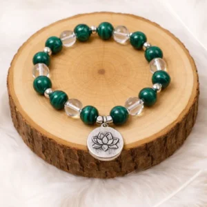 Bracelet énergétique anti douleur en malachite et cristal de roche posé sur rondin de bois
