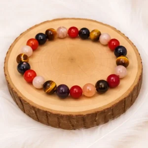 Bracelet porte bonheur en œil de tigre pierre de soleil cornaline et grenat posé sur rondin