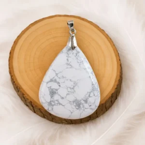 Pendentif howlite goutte posé sur rondin en bois