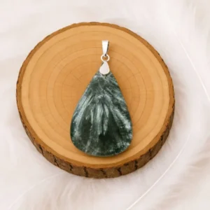 Pendentif séraphinite naturelle posé sur rondin de bois avec bélière en argent