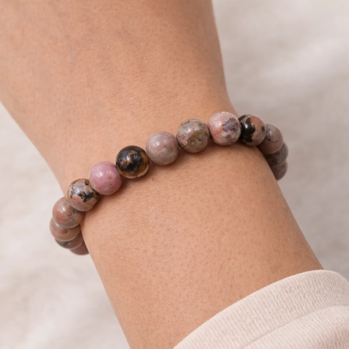 Bracelet rhodonite en pierre naturelle porté au poignet