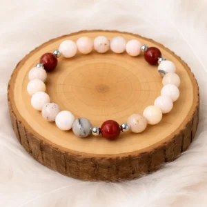 Bracelet en jaspe fleur de cerisier et jaspe rouge posé sur rondin en bois