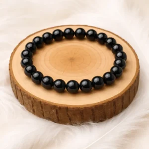 Bracelet en obsidienne noire naturelle posé sur rondin en bois