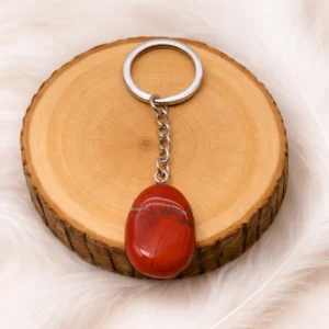 Porte-clés jaspe rouge naturel présenté sur rondin en bois
