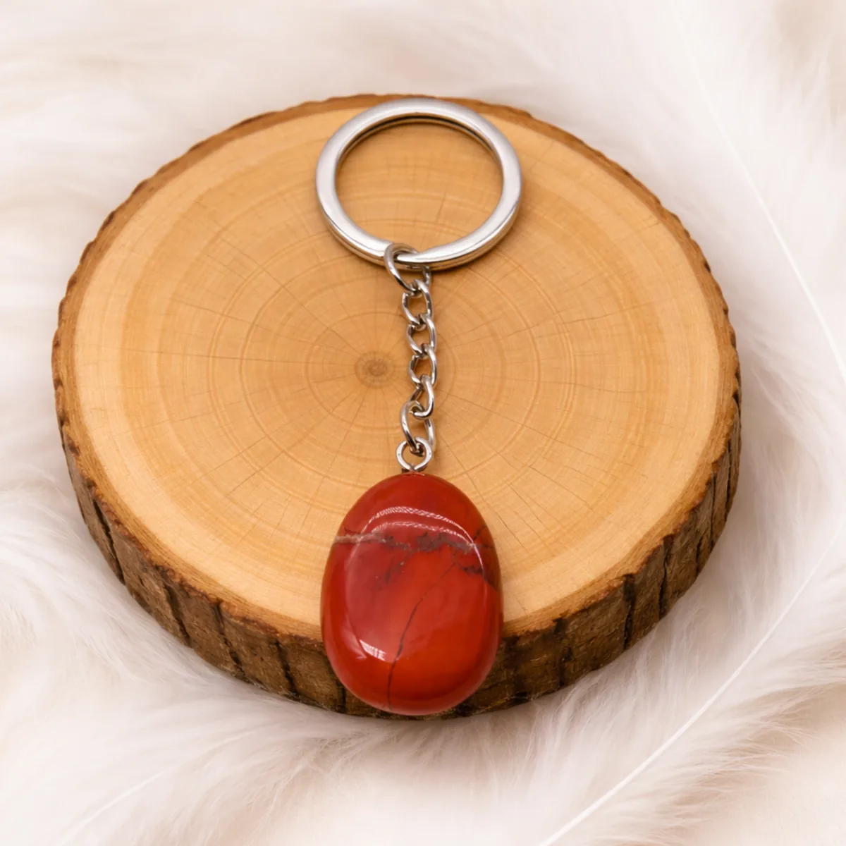 Porte-clés jaspe rouge naturel présenté sur rondin en bois
