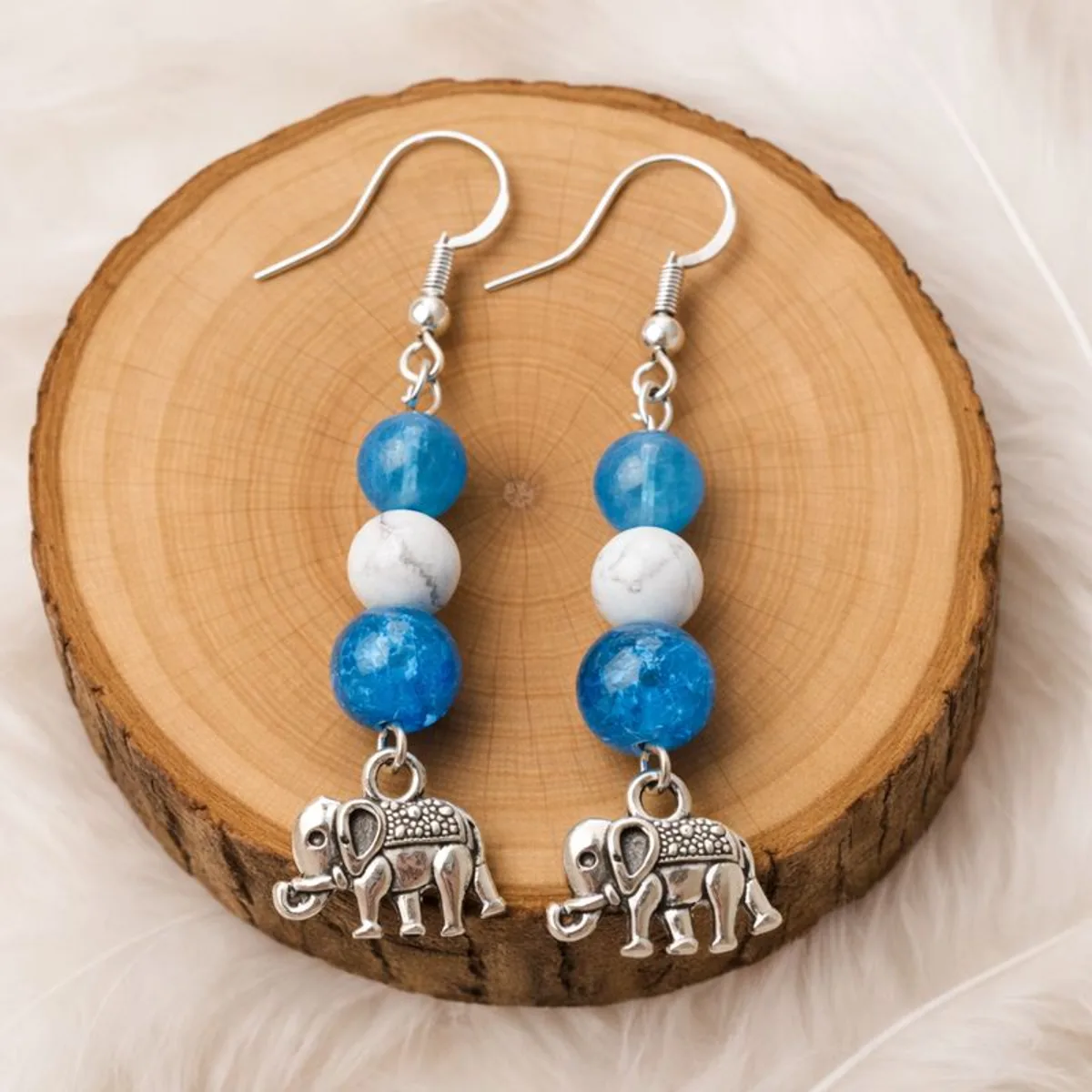 Boucles d’oreilles en apatite bleue et howlite blanche présentées sur rondin en bois