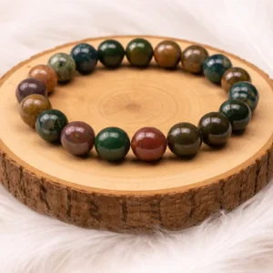 Bracelet en agate indienne naturelle présenté sur rondin en bois fond doux