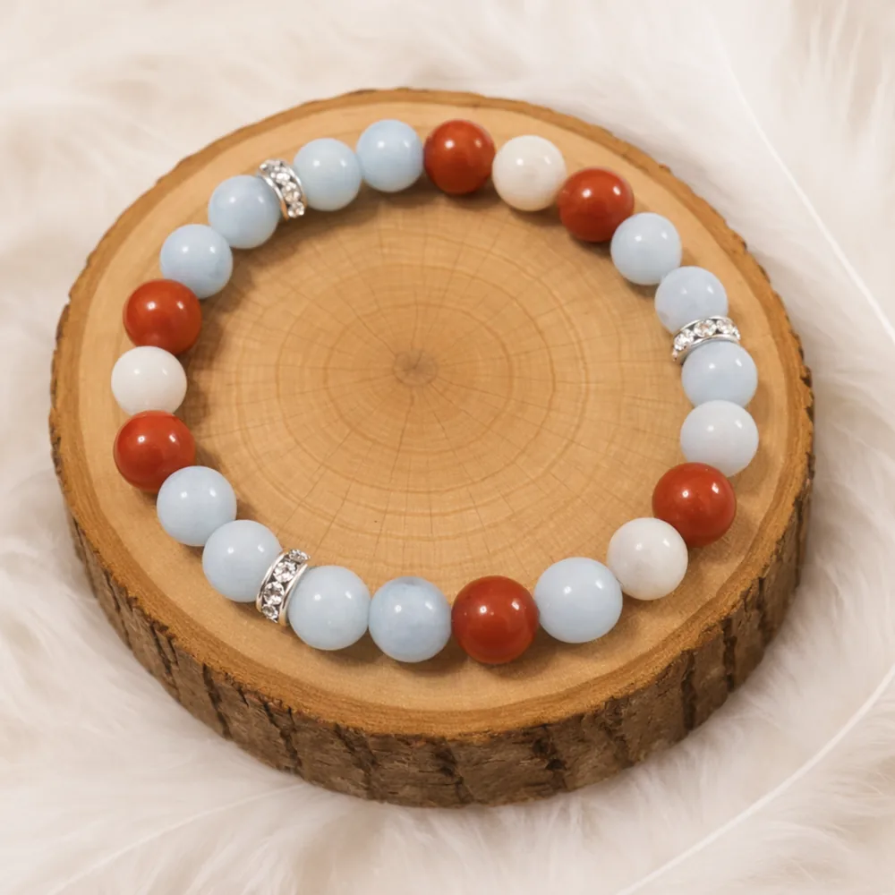 Bracelet en aigue-marine, jaspe rouge et pierre de lune posé sur un rondin en bois