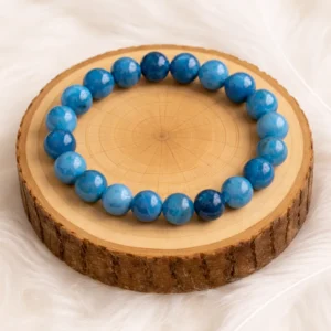 Bracelet en apatite bleue 10 mm qualité AA posé sur rondin en bois naturel