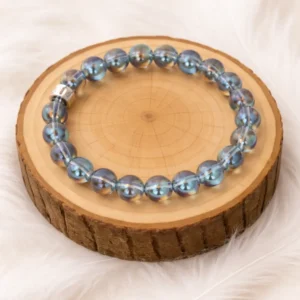 Bracelet aqua aura bleu en pierres naturelles posé sur rondin en bois
