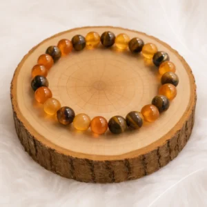 Bracelet en cornaline et œil de tigre perles 8 mm présenté sur rondin en bois naturel