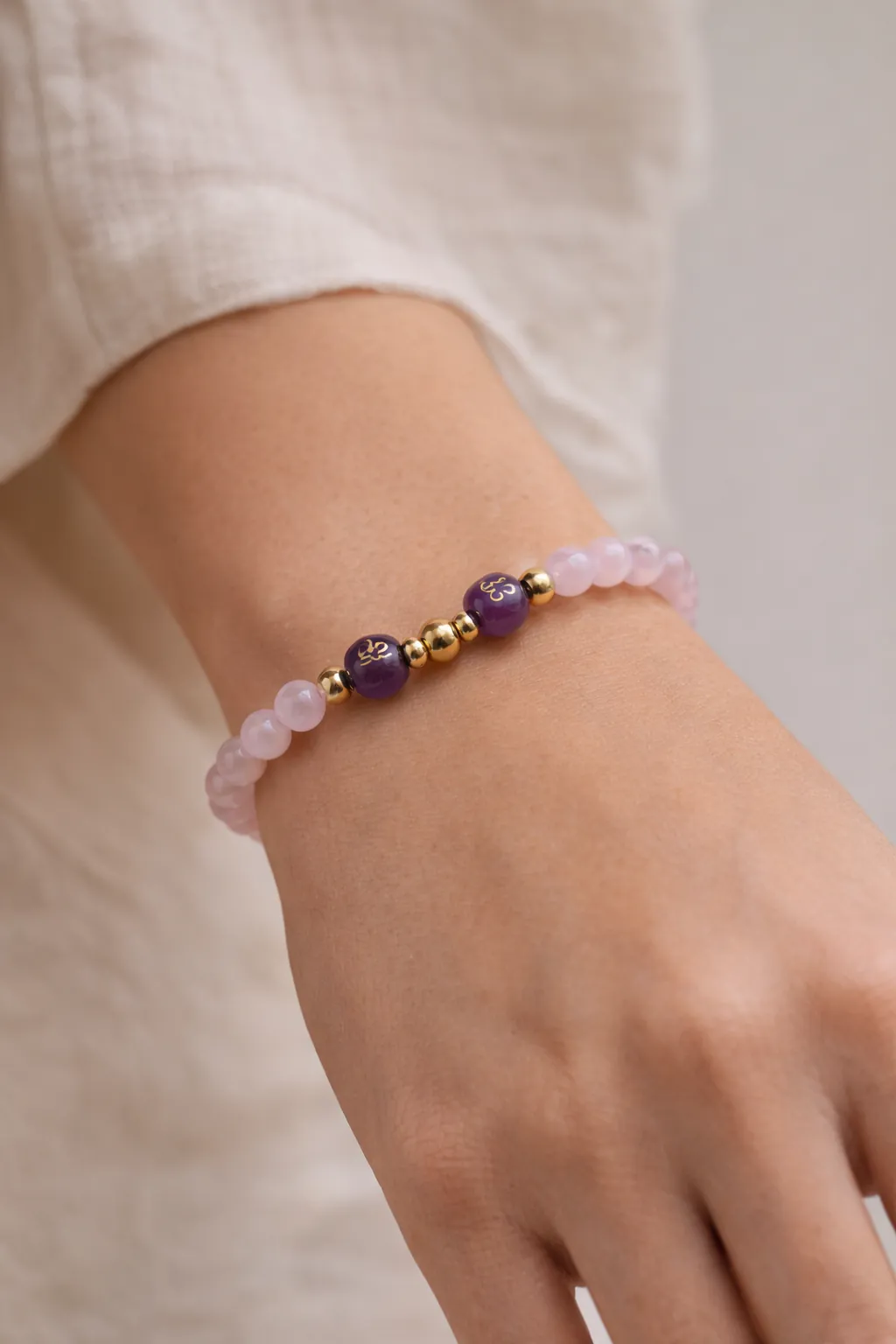 Bracelet en quartz rose et améthyste porté au poignet féminin