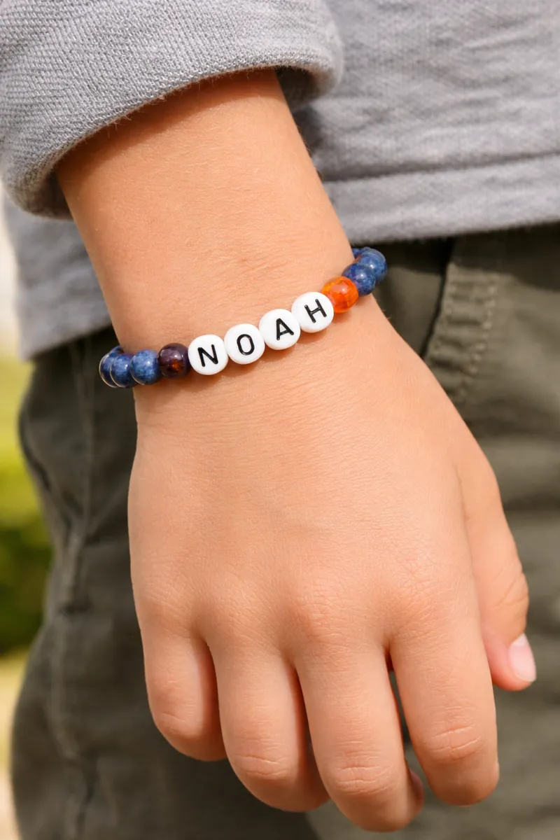 Bracelet prénom enfant NOAH en pierres naturelles porté par un garçon
