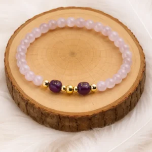 Bracelet en quartz rose et améthyste posé sur rondin en bois naturel