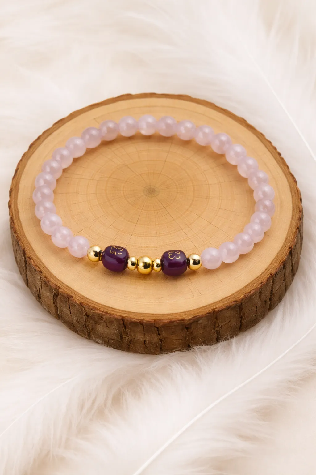Bracelet en quartz rose et améthyste posé sur rondin en bois naturel