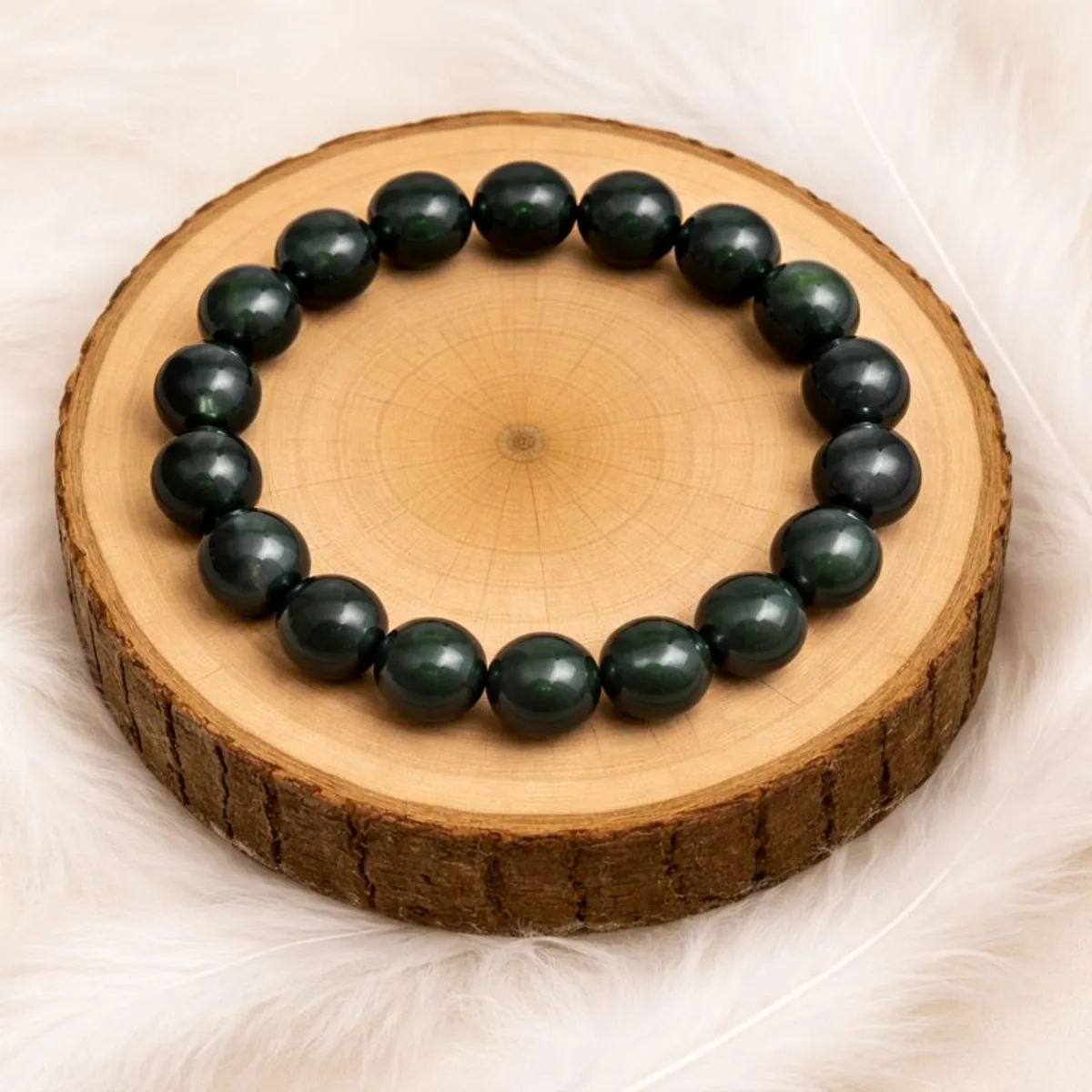 Bracelet tourmaline œil de chat posé sur rondin en bois naturel