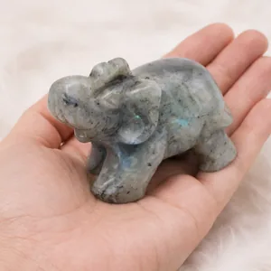 Éléphant en labradorite sculpté tenu dans une main pour montrer la taille