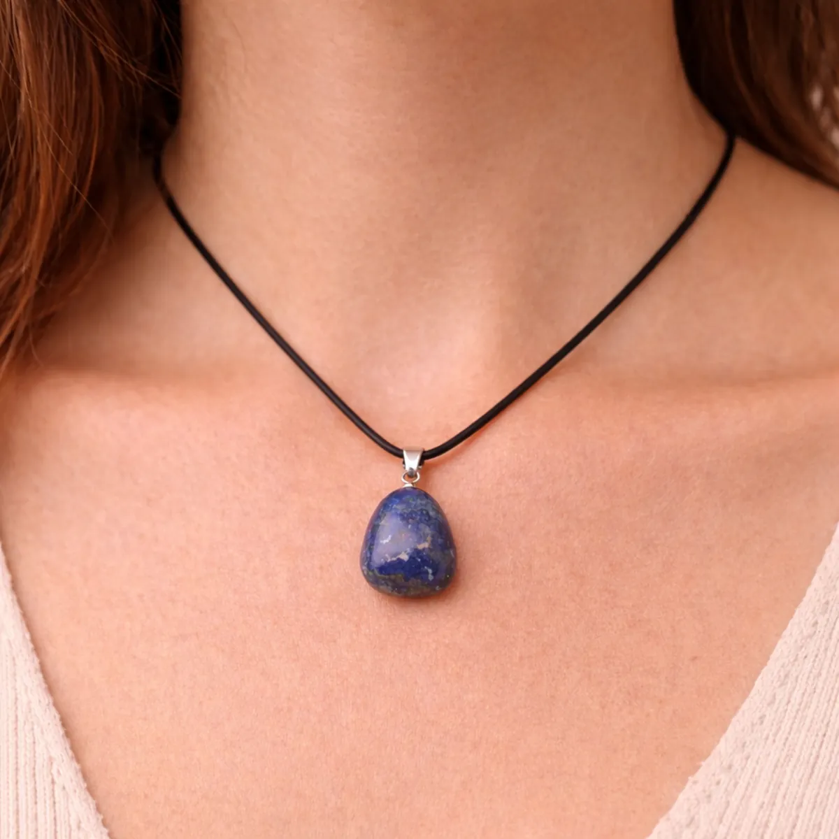 Pendentif Lapis-Lazuli roulé bleu naturel porté autour du cou sur cordon noir