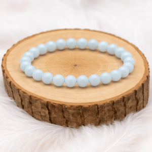 Bracelet aigue-marine en pierre naturelle présenté sur rondin en bois avec perles bleu clair