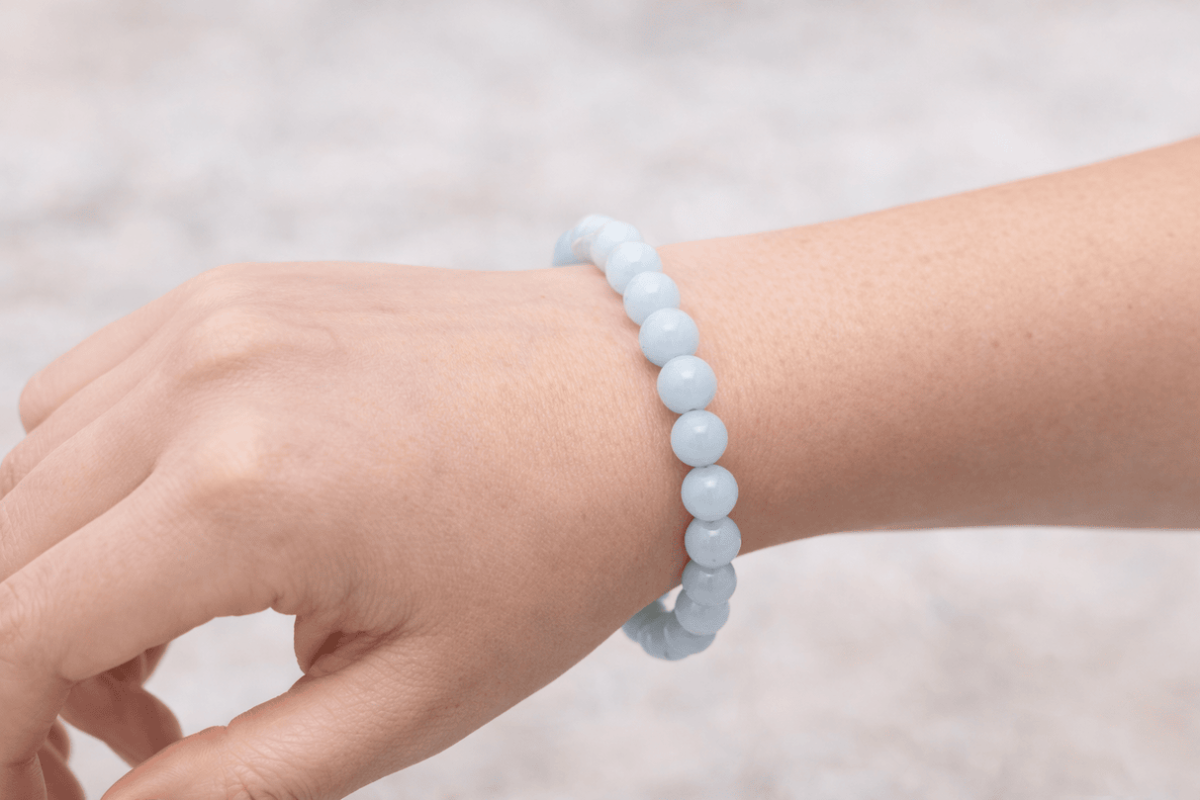 Bracelet en aigue-marine naturelle porté au poignet avec perles rondes bleu clair en pierre naturelle