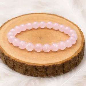 bracelet quartz rose en pierres naturelles posé sur rondin en bois