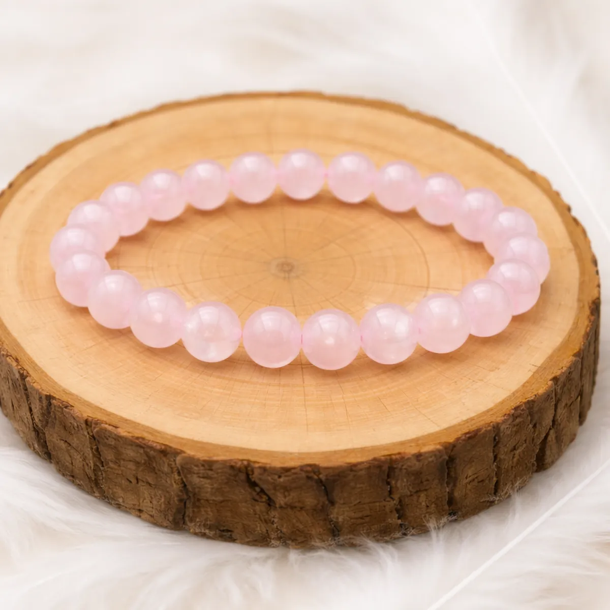 bracelet quartz rose en pierres naturelles posé sur rondin en bois