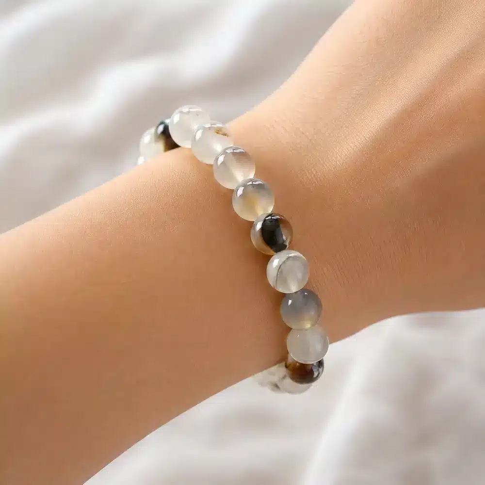 Bracelet en agate du Montana porté au poignet, bijou artisanal en pierre naturelle aux perles translucides