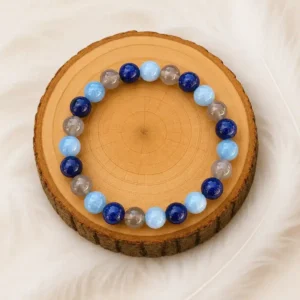 Bracelet allergie en pierres naturelles bleues et grises présenté sur un rondin en bois