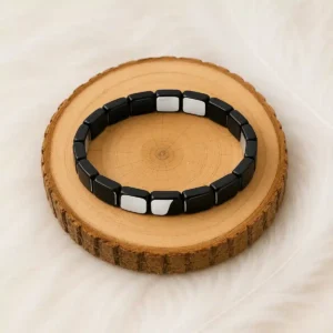 Bracelet en hématite présenté sur un rondin de bois