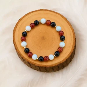 Bracelet reconstruction après un deuil en Onyx, Cornaline et Amazonite présenté sur un rondin en bois