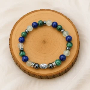 Bracelet soulagement des articulations en malachite, lapis-lazuli, fluorite et hématite présenté sur un rondin