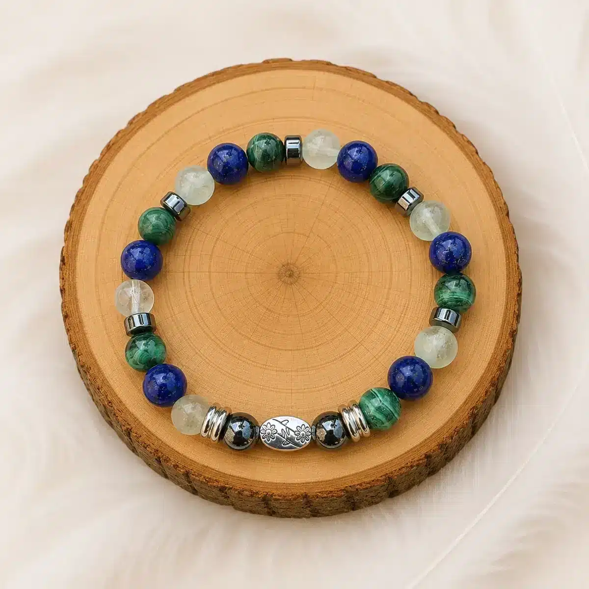 Bracelet soulagement des articulations en malachite, lapis-lazuli, fluorite et hématite présenté sur un rondin