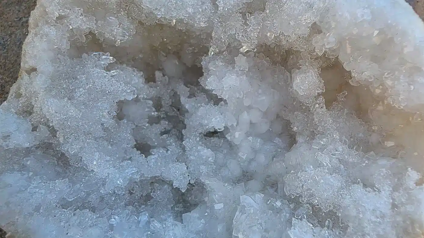 Gros plan sur les cristaux brillants d’une géode de quartz blanc naturelle