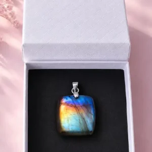 Boîte cadeau blanche ouverte contenant un pendentif en labradorite aux reflets bleus et dorés