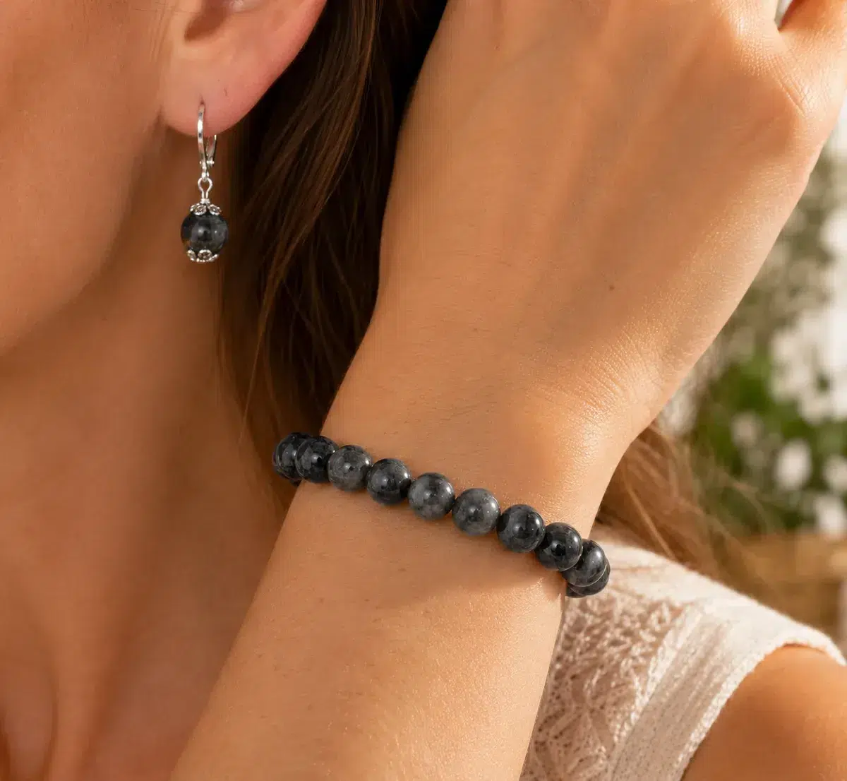 Femme portant un bracelet et des boucles d’oreilles en larvikite naturelle
