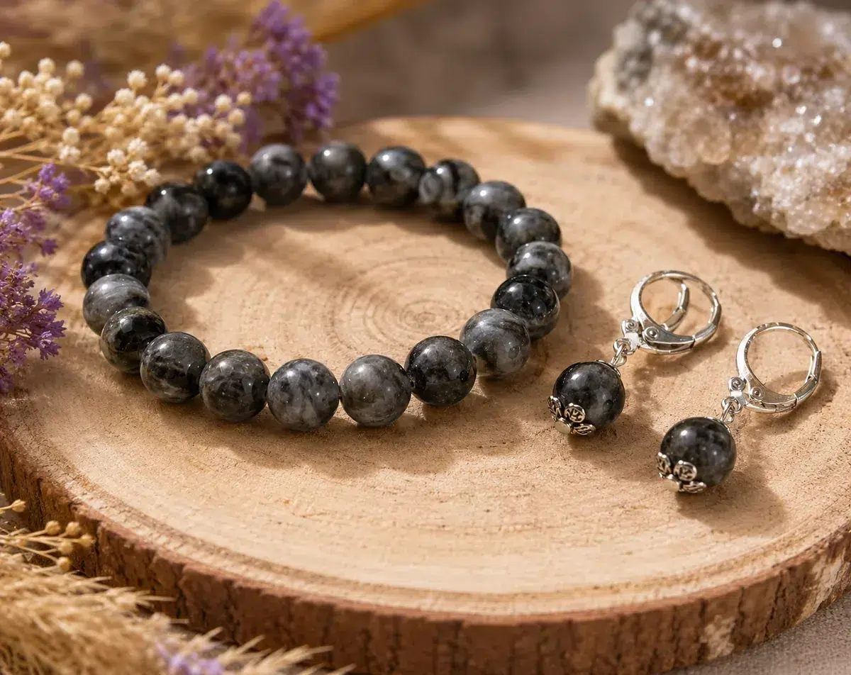 Bracelet et boucles d’oreilles en larvikite naturelle présentés sur un rondin de bois