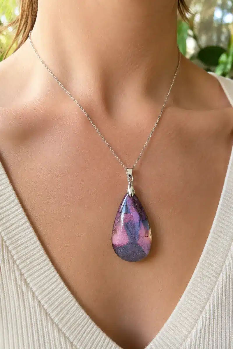 Pendentif en Jaspe Mokaïte naturel aux nuances roses et violettes porté autour du cou