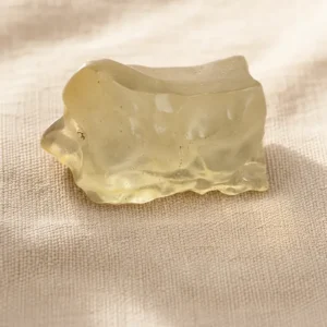 Vue de profil d’une tectite dorée brute en verre libyque naturel