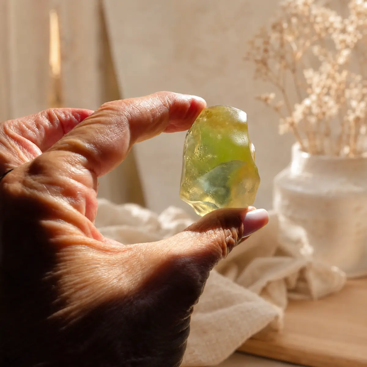 Verre libyque translucide jaune et vert tenu à la lumière naturelle